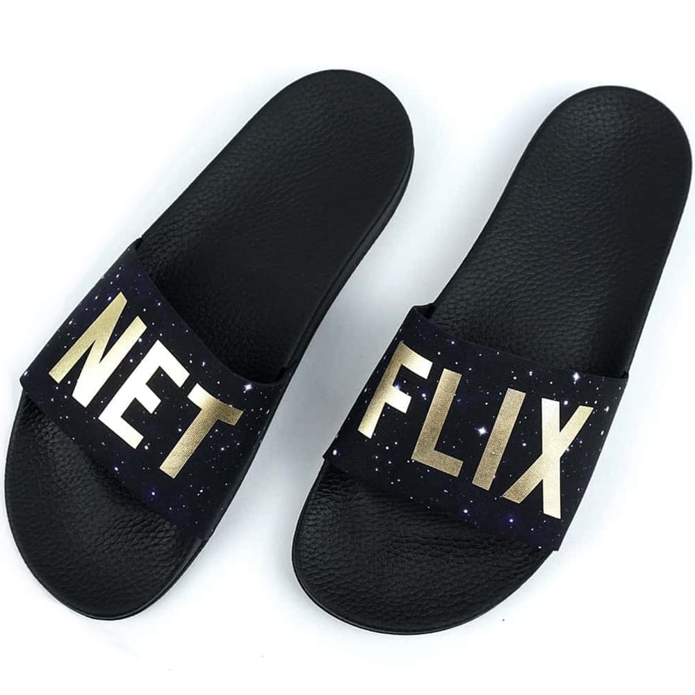Black custom slides with gold Netflix lettering across the straps