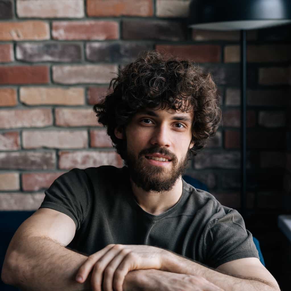 Man in dim, uneven light — half the face is in shadow